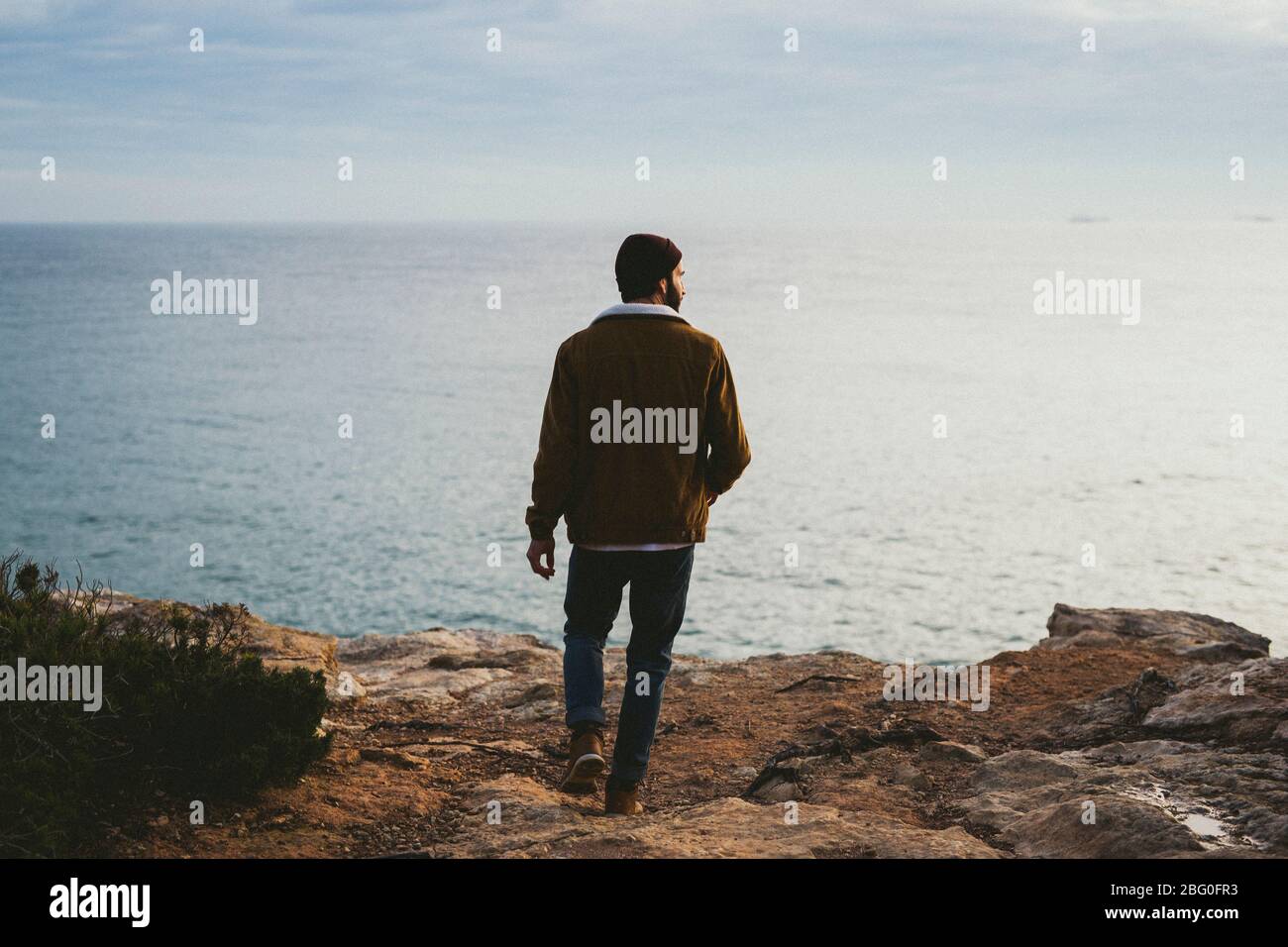 Porträt des jungen Mannes, der im Freien am Meer spazieren geht Stockfoto