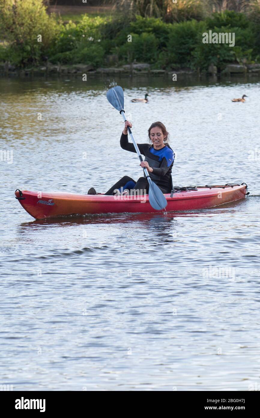 Kajakfahrerin paddeln auf dem Trenance Bootsee in Newquay in Cornwall. Stockfoto