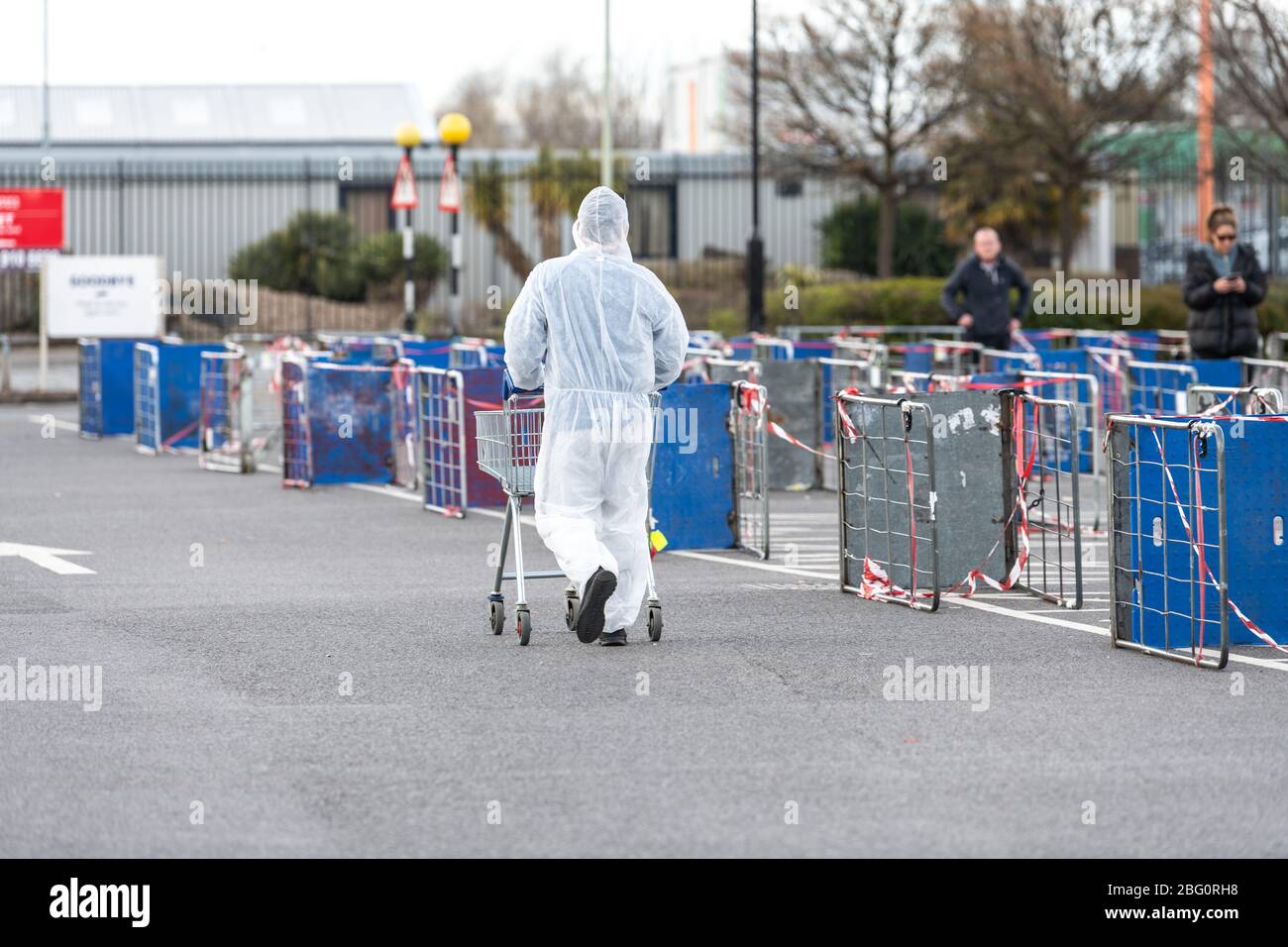 Shopper trägt einen vollen Hasmatanzug und Maske im Cheltenham Tesco Superstore während der Coronavirus-Pandemie. Stockfoto