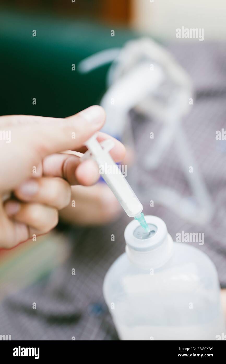 Vorbereitung des Kompressorverneblers für den Einsatz auf älteren Mann mit Atemschutzmaske, Vernebler im Raum Stockfoto