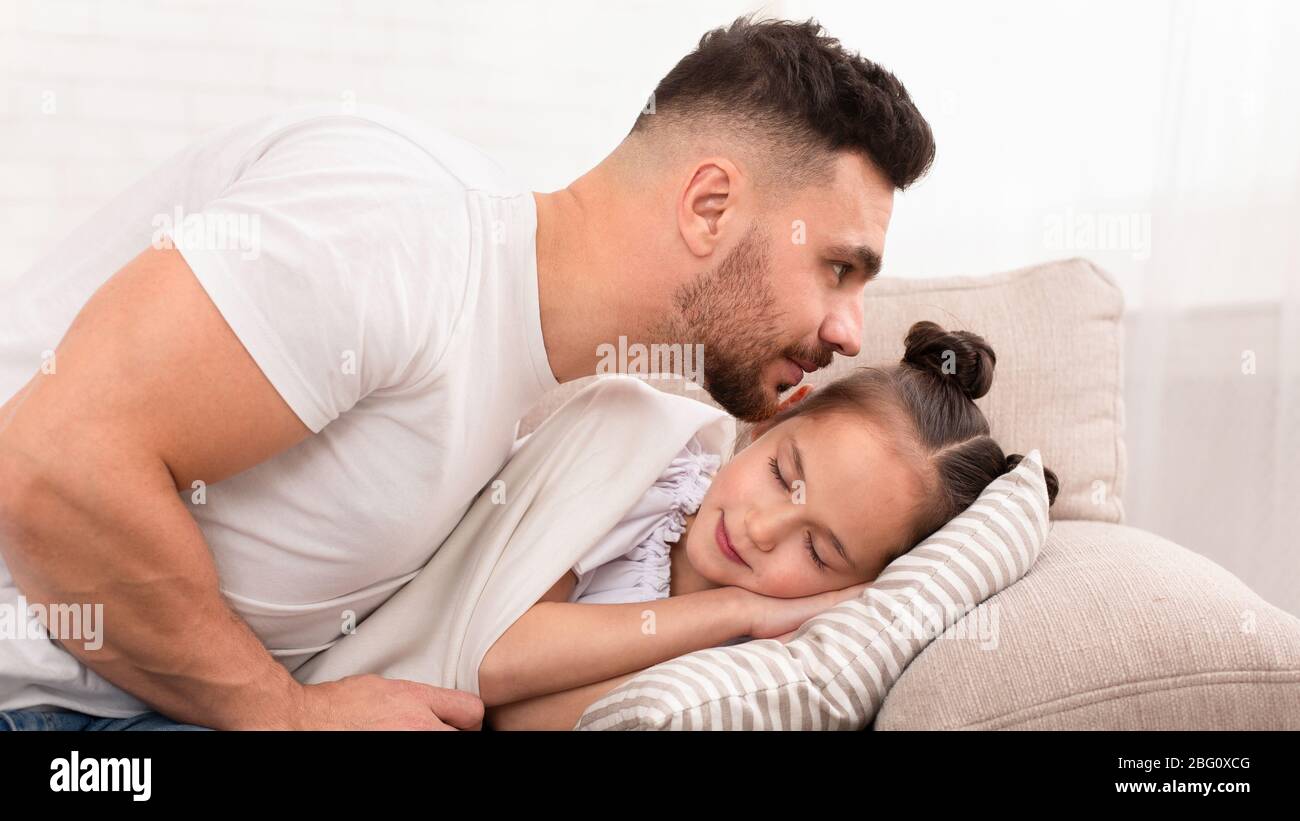 Papa küssen seine schlafend liebenswert Tochter zu Hause Stockfoto
