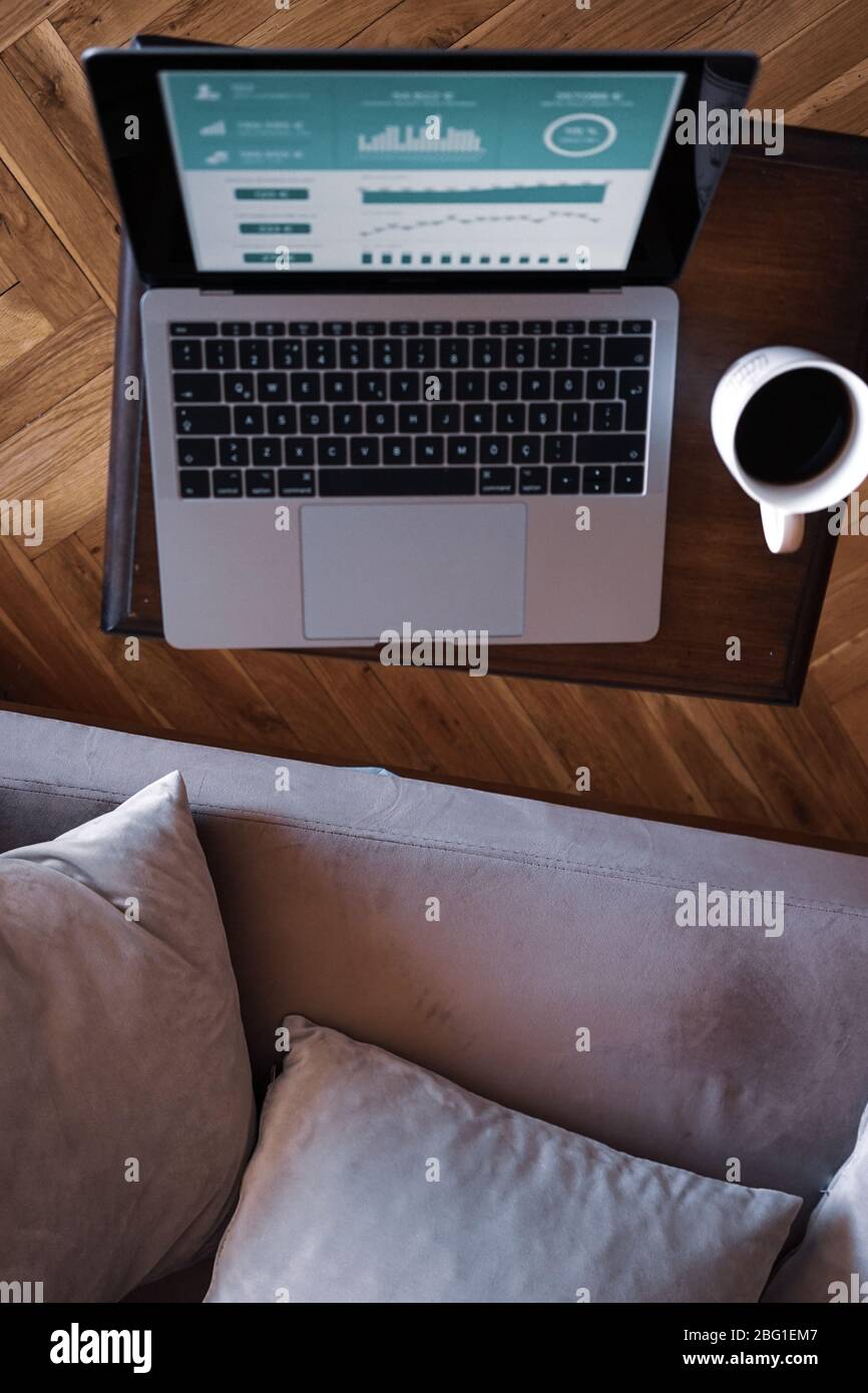 Home Office wird immer beliebter auf der ganzen Welt. Arbeiten Sie mit einer Tasse Kaffee mit Ihrem Notebook auf dem Stuhl. Komfortables Arbeiten. Stockfoto