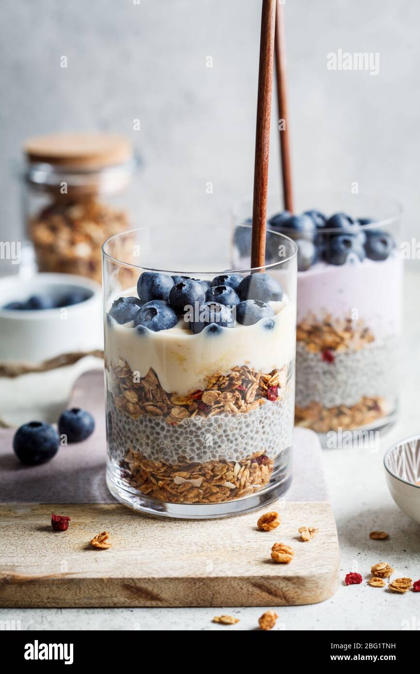 Frühstück Parfait mit Chia, Müsli, Beeren und Joghurt im Glas. Dessert in ein Glas einschichten. Stockfoto