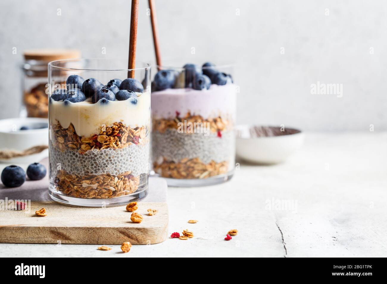 Frühstück Parfait mit Chia, Müsli, Beeren und Joghurt im Glas. Dessert in ein Glas einschichten. Stockfoto