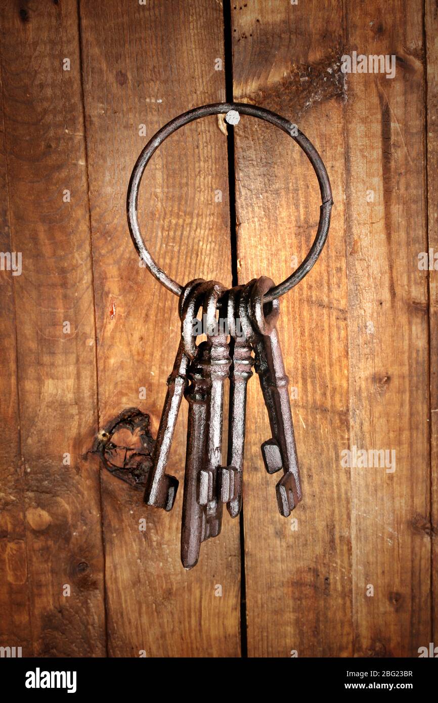 Ein Haufen alter Schlüssel hängen an der Holzwand Stockfoto