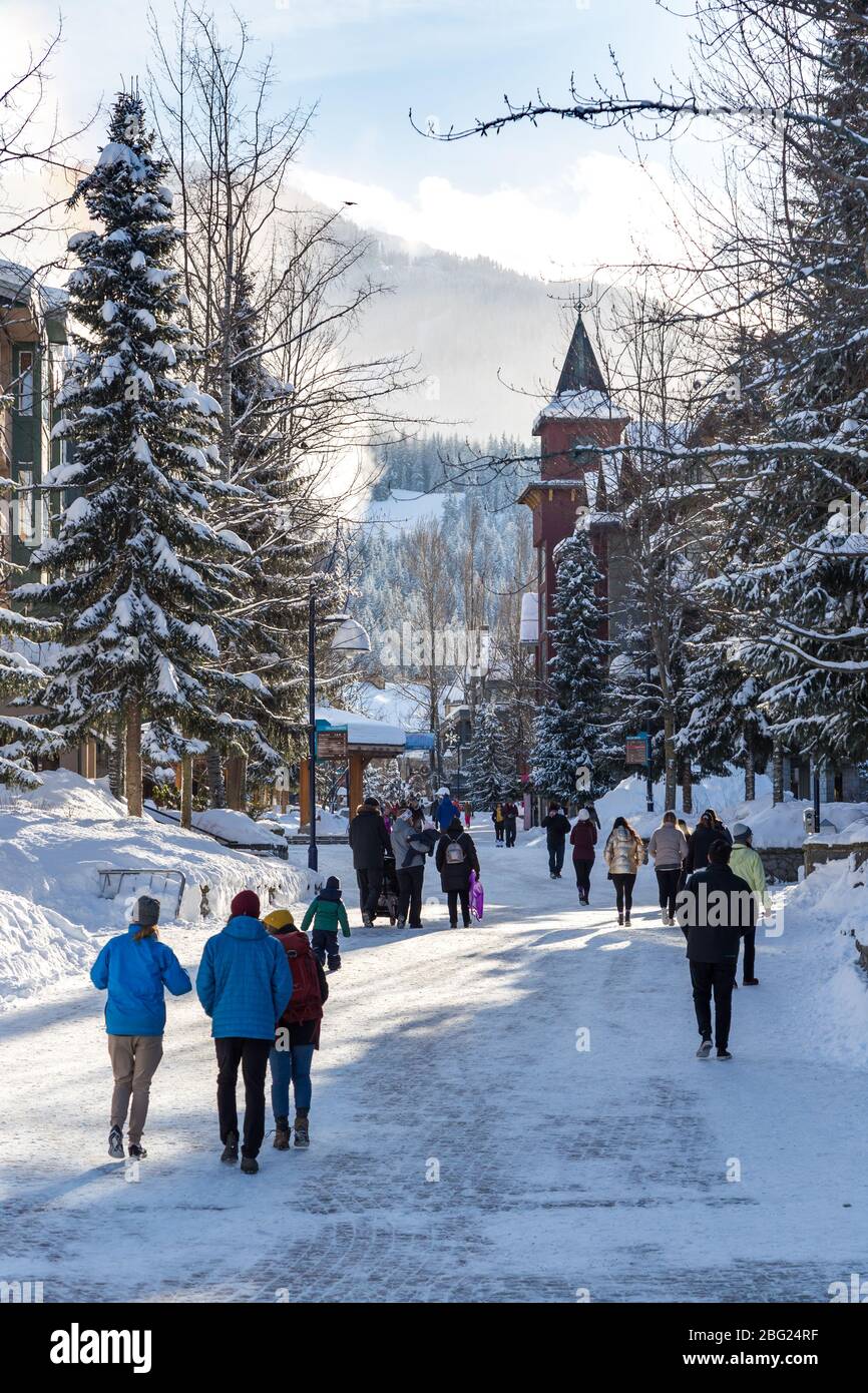 Menschen, die in Whistler Village, Kanada, herumlaufen, wo es viele Geschäfte und Restaurants gibt. Gesichter und Zeichen verschwimmen. Stockfoto