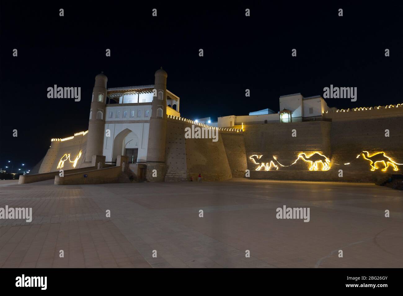 Mauer der Buchara-Festung (Arche) in Buchara, Usbekistan bei Nacht. Massive Festung genannt Arche von Buchara. Befestigte Ziegelwand beleuchtet. Stockfoto