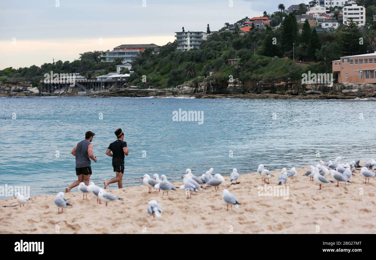 Sydney. April 2020. Männer laufen am Coogee Beach in Sydney, Australien am 20. April 2020. Die Einheimischen sind zum ersten Mal seit drei Wochen ins Wasser gegangen, da die drei Strände von Sydney zum ersten Mal seit der Verlangsamung der COVID-19-Ausbreitung geöffnet sind. Kredit: Bai Xuefei/Xinhua/Alamy Live News Stockfoto