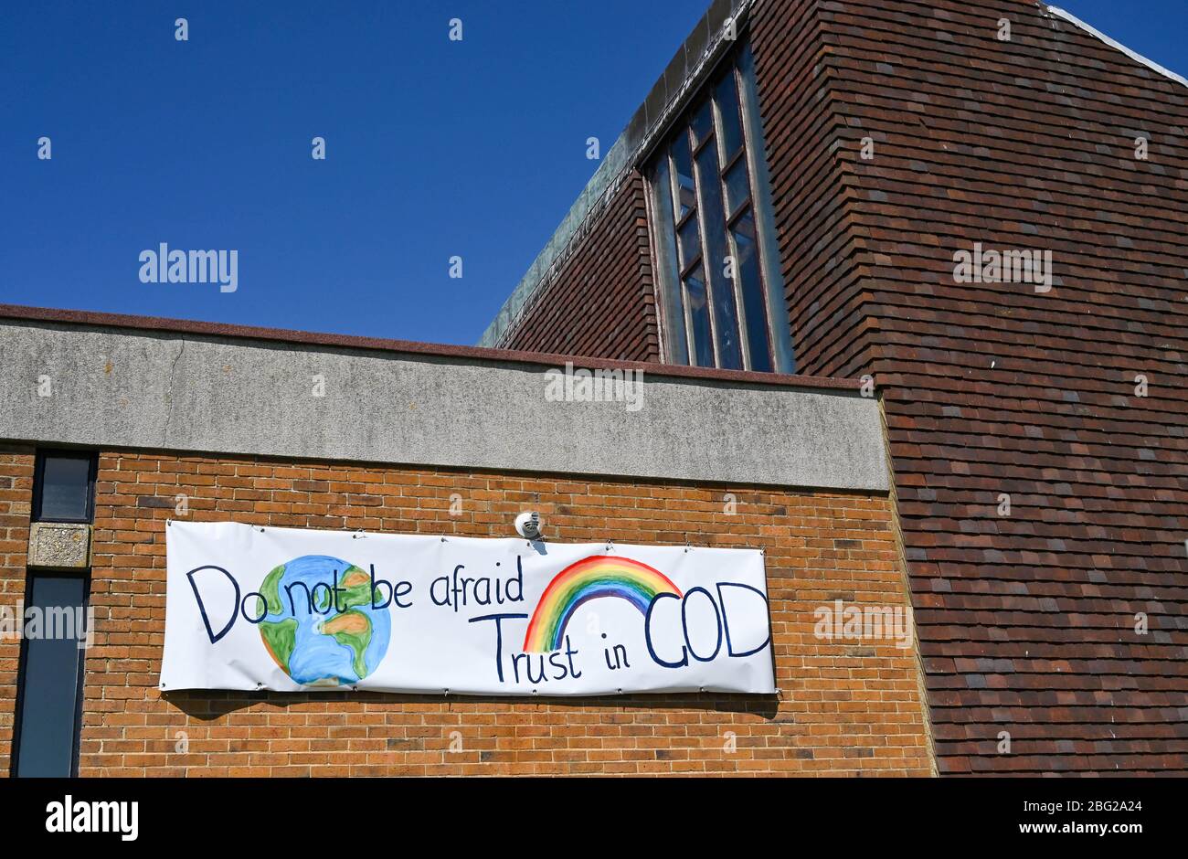 Brighton UK 20. April 2020 - EIN Regenbogenbanner der Hoffnung vor der Kirche des Heiligen Kreuzes in Woodingdean bei Brighton während der COVID-19 Pandemiekrise. Quelle: Simon Dack / Alamy Live News Stockfoto