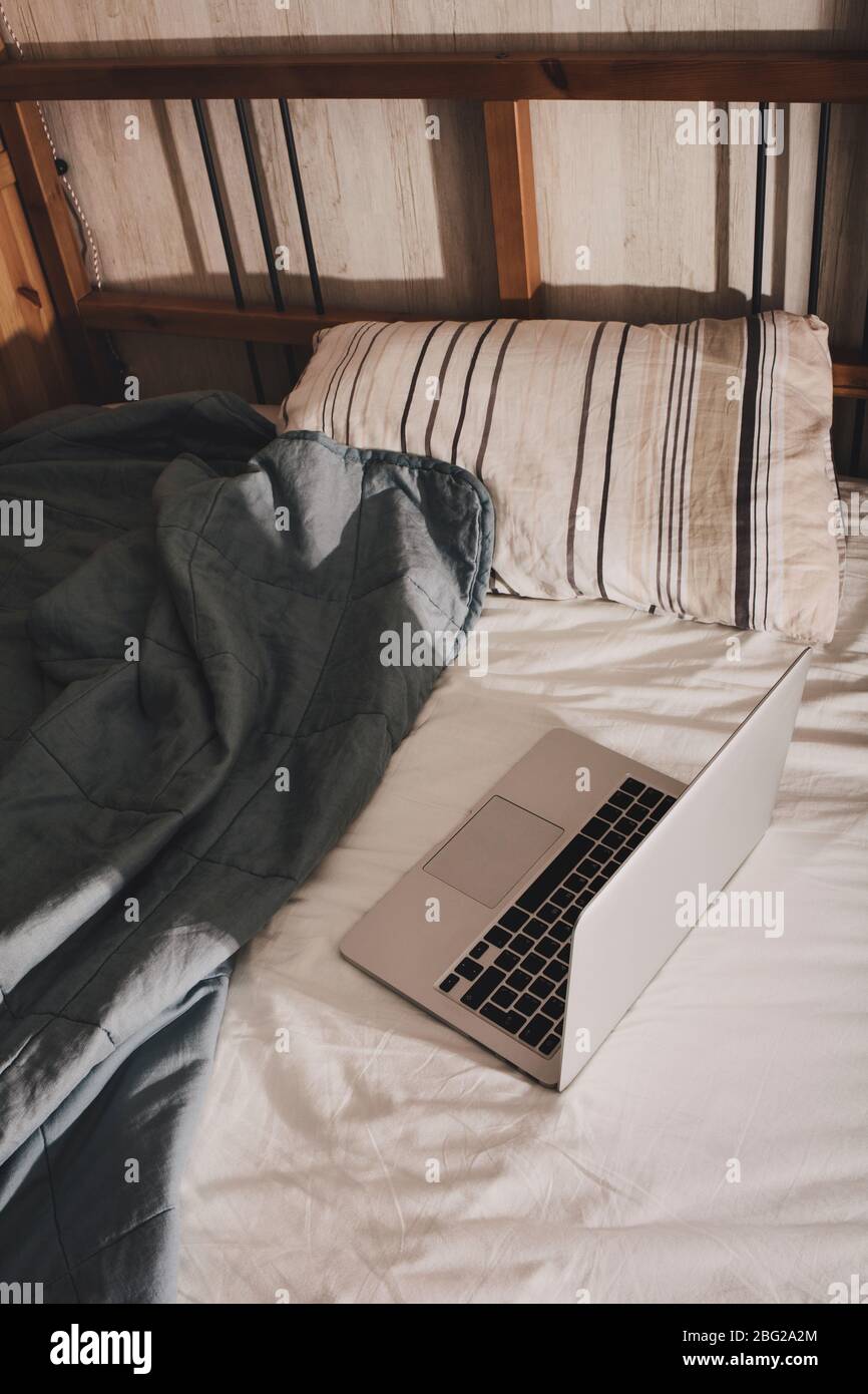 Arbeiten Sie von zu Hause aus. Der Laptop liegt auf dem Bett. Eine Pause während der Arbeit. Stockfoto