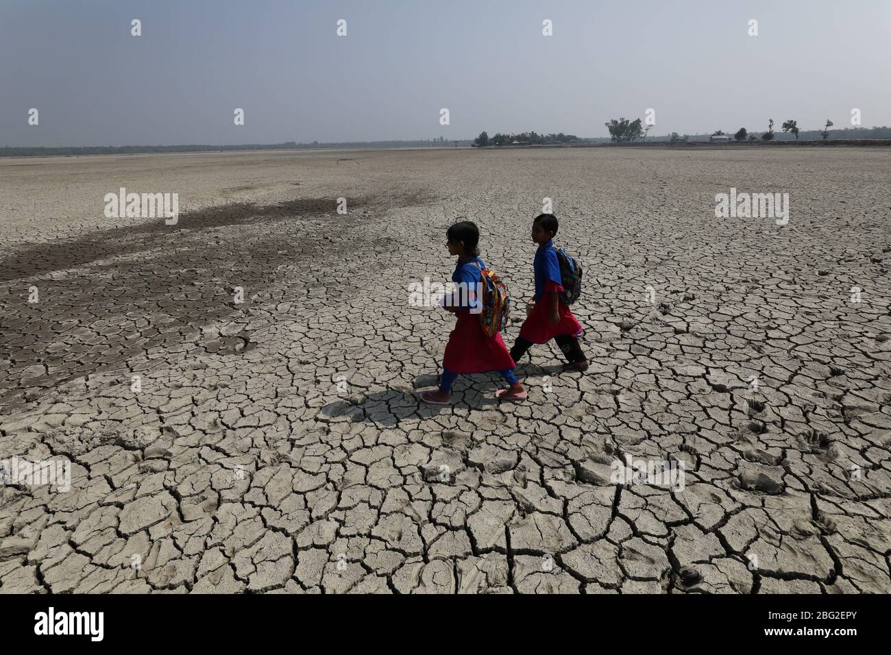 Khulna, Bangladesch: Schulmädchen gehen nach der besuchten Schule am Rande des Sundarbans Mangrovenwaldes, dem Welterbe, in Bangladesch nach Hause. Das Leben der Menschen wird durch die Auswirkungen des Klimawandels jeden Tag schlechter. Die meisten Menschen sind für ihren Lebensunterhalt auf den Wald angewiesen. Die Wasserkrise ist eines der größten Probleme in ihrem Leben, da salzhales Wasser über die Küste in Bangladesch geht. Die meisten Menschen haben an die Flüsse gefischt, einige von ihnen sammeln Honig und Holz aus dem Mangrovenwald. In der Trockenzeit leiden die Menschen unter reinem Trinkwasser. Stockfoto
