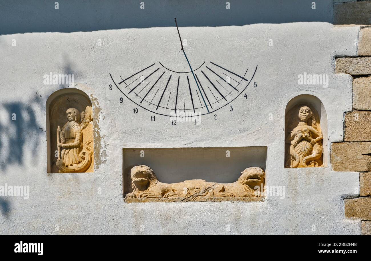 Vorchristliche Skulpturen, Sonnenuhr an der Wand der Ungarischen Reformierten Kirche, 13. Jahrhundert, im Dorf Manastireni, in der Nähe von Huedin, Siebenbürgen, Rumänien Stockfoto