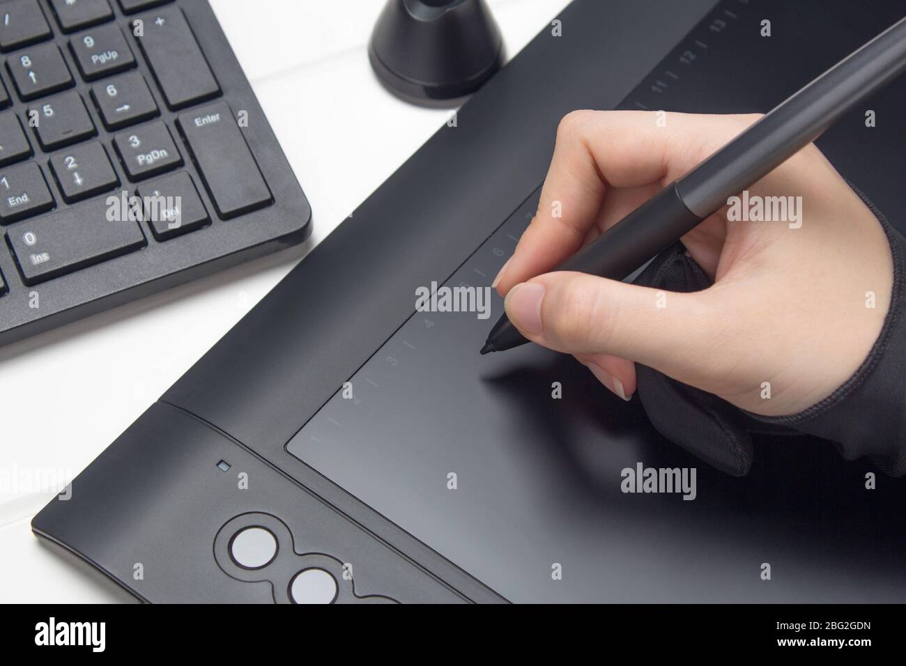 Grafikdesigner, der an einem digitalen Tablet arbeitet. Die Hand zeichnet auf einem Grafiktablett. Freiberufliche/r, Designer/in, Illustrator. Technologie, Remote-Arbeit, Outsourcing Stockfoto