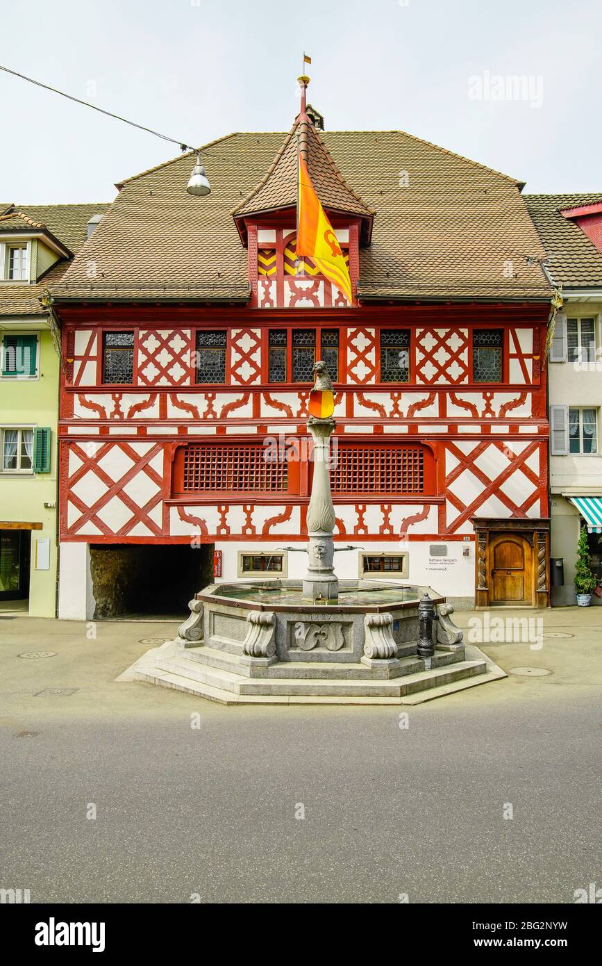 Vorderansicht des Rathauses und des Stadtbrunnens in Sempach, Kanton Luzern, Schweiz. Stockfoto