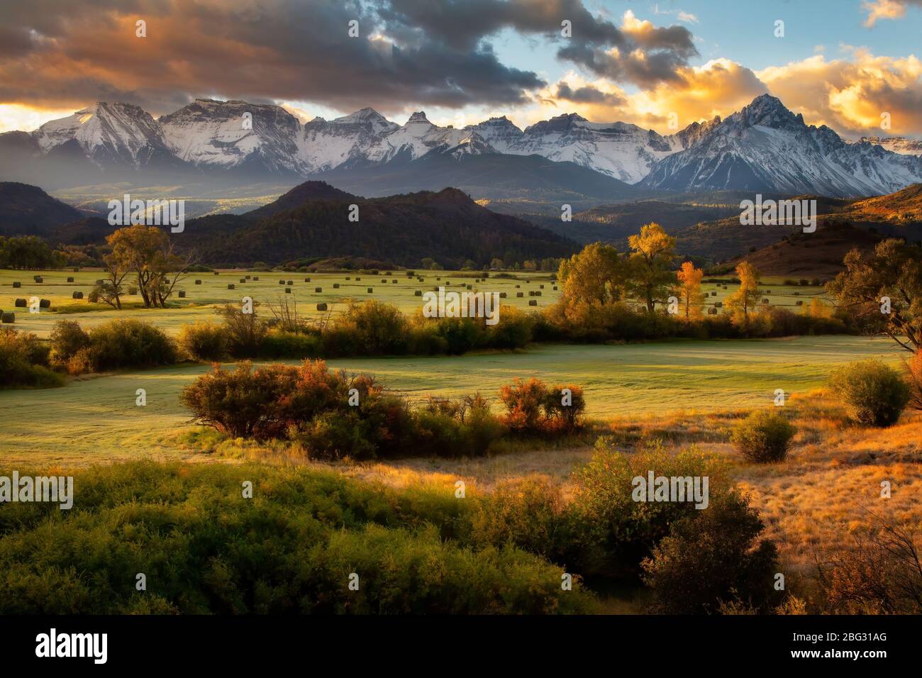 Bails of Hay sind die Herbstlandschaft, während die Sonne entlang der Dallas Divide im Südwesten Colorados aufgeht Stockfoto