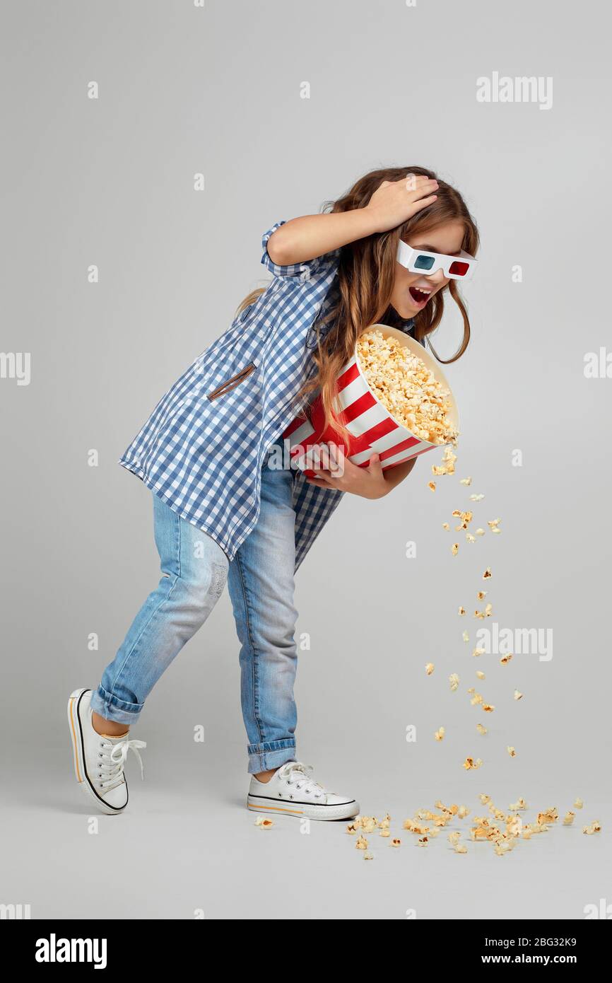 In voller Länge Ansicht von kaukasischen Mädchen in rot-blauen 3d-Brille so eilig zum Kino, dass sie Popcorn aus einem Eimer auf den Boden fallen gelassen Stockfoto