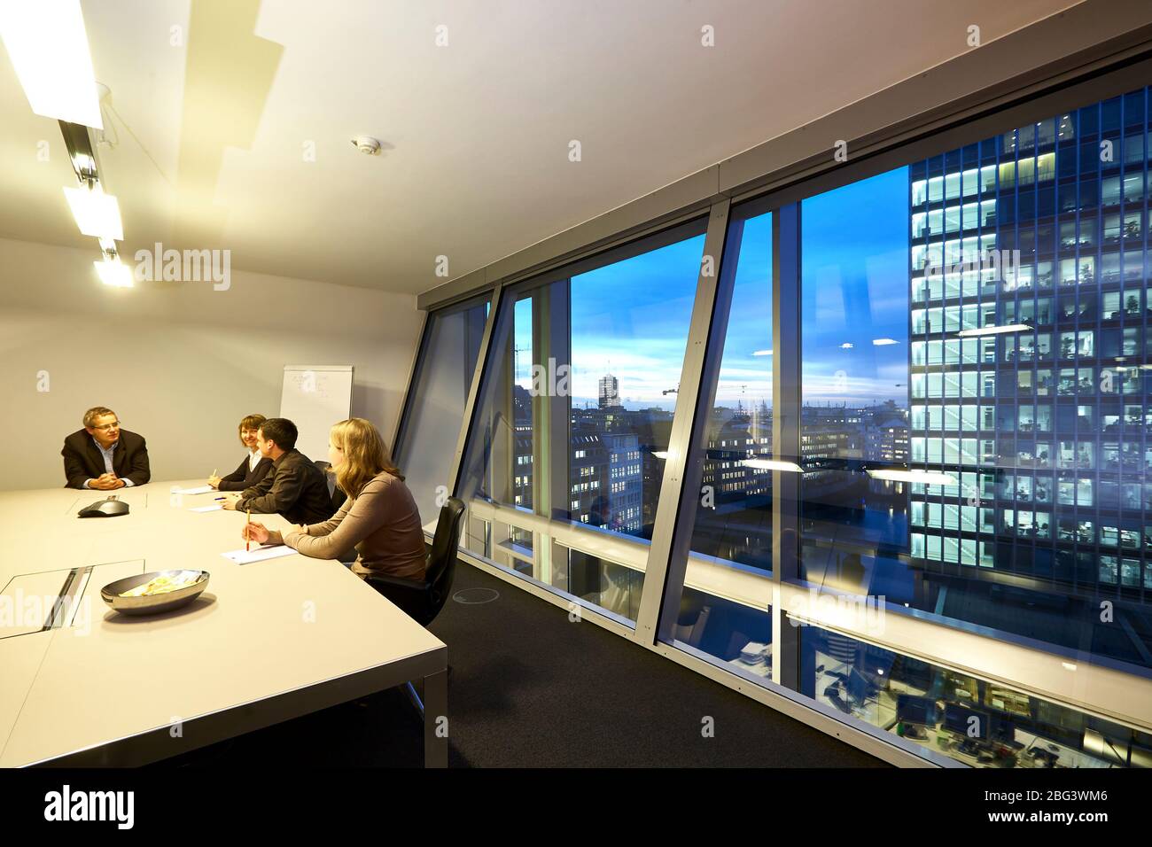 Ein Geschäftstreffen in einem Büro mit Blick auf die Nikolaifleet und das Gebäude der Reederei Hamburg Süd. Stockfoto
