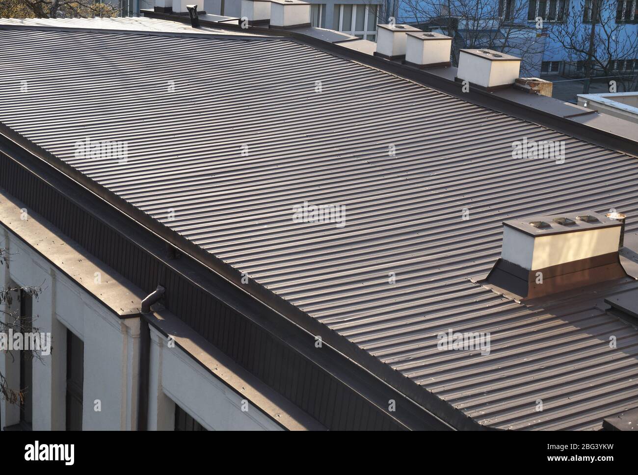 Das Dach ist mit lackierten Metallpaneelen überzogen. Großer Dachbereich des Gebäudes. Stockfoto