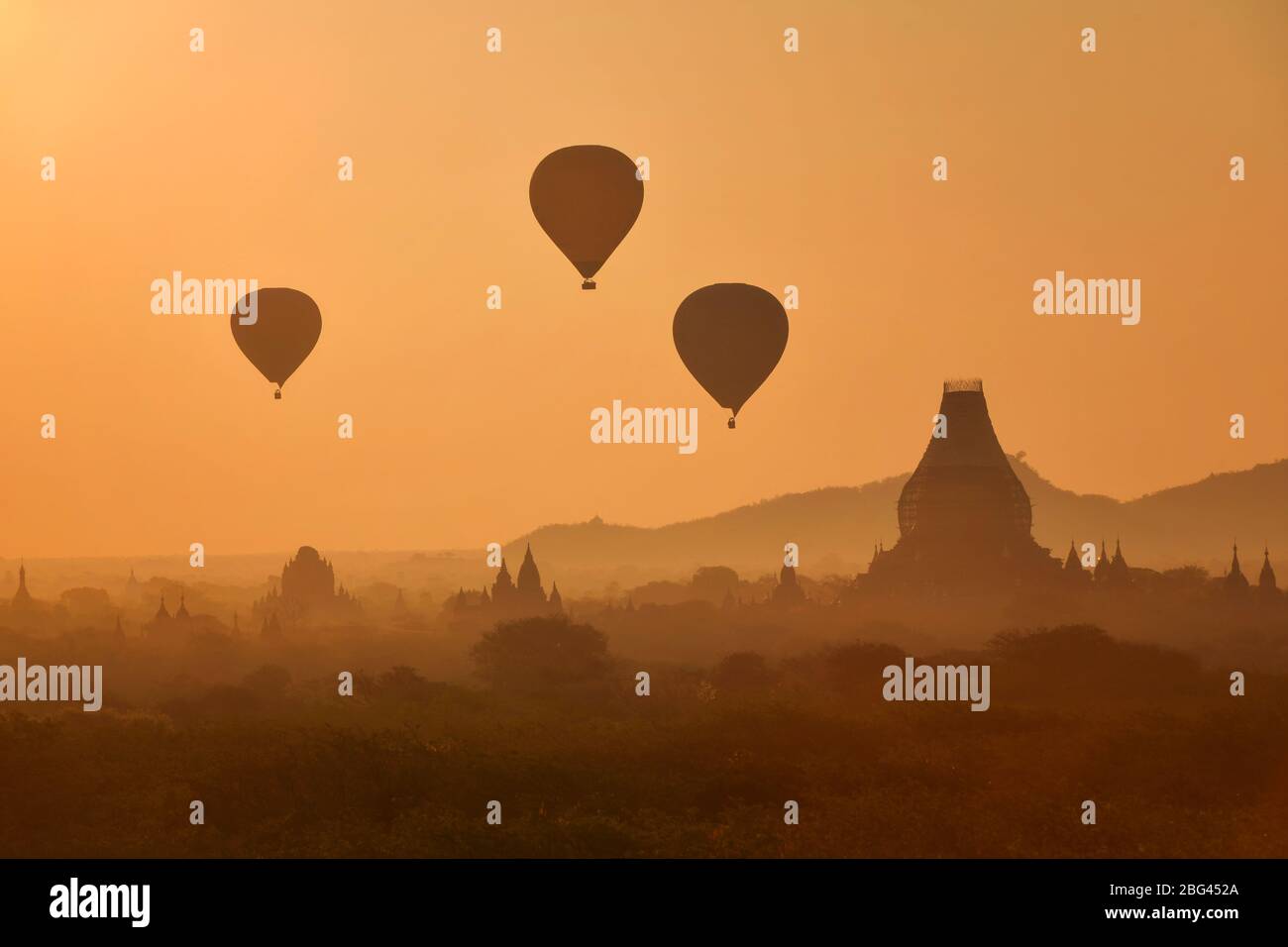 Heißluftballons fliegen bei Sonnenaufgang über Bagan, Mandalay, Myanmar Stockfoto
