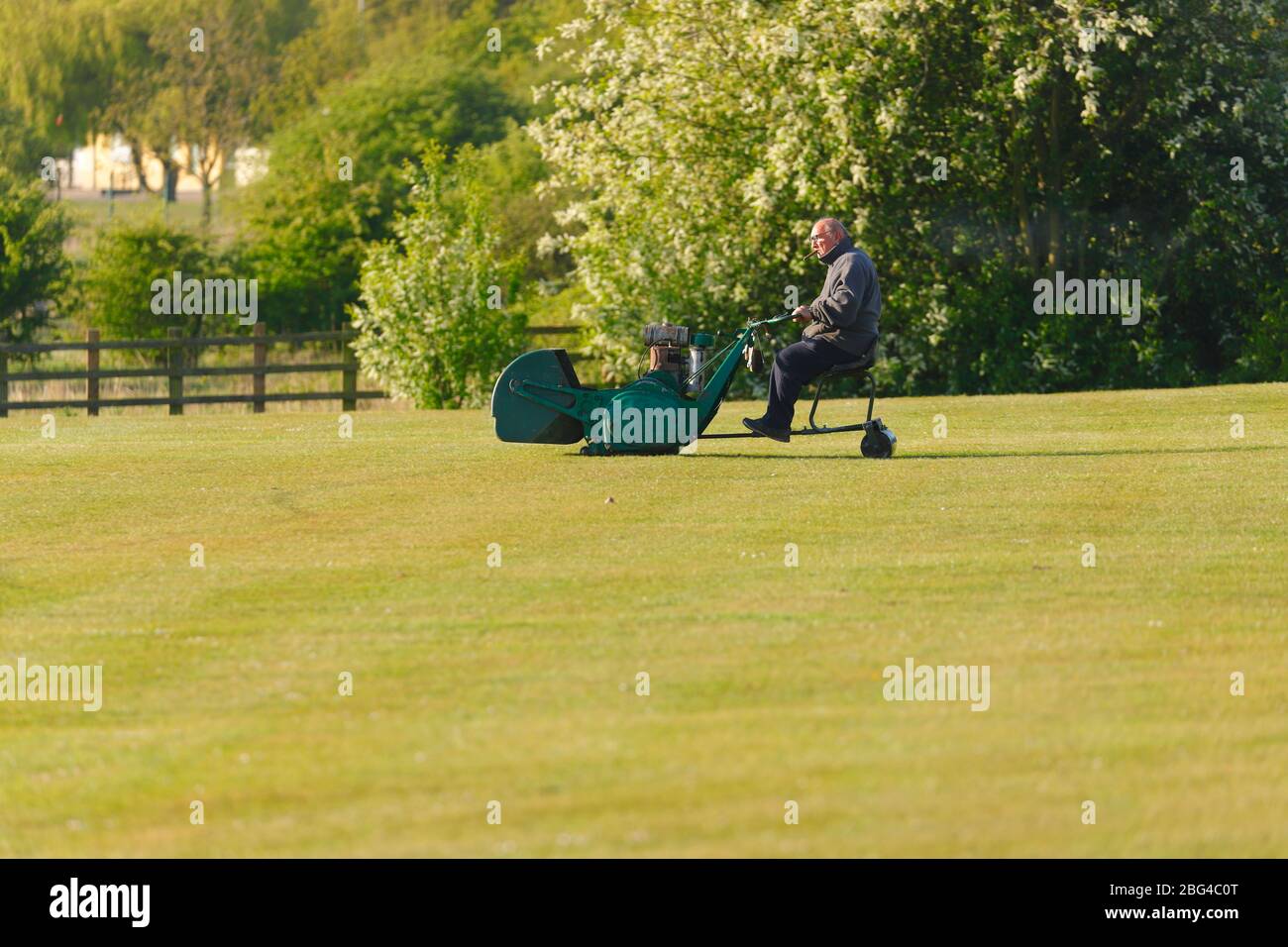 Ein Grundbesitzer, der den Cricket-Platz auf einer Ransomes-Fahrt mit dem Mäher in Great Preston, Leeds, hält Stockfoto