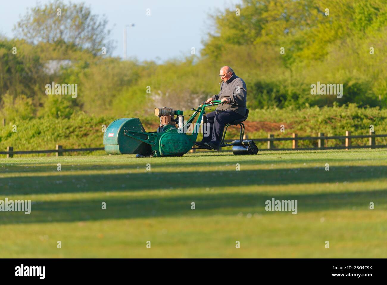 Ein Grundbesitzer, der den Cricket-Platz auf einer Ransomes-Fahrt mit dem Mäher in Great Preston, Leeds, hält Stockfoto