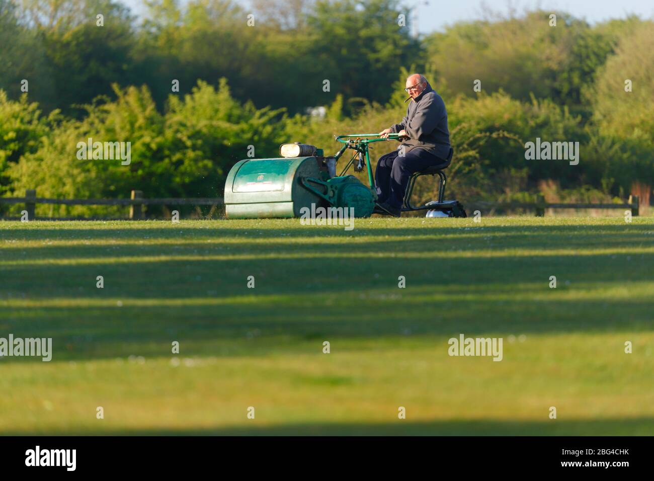 Ein Grundbesitzer, der den Cricket-Platz auf einer Ransomes-Fahrt mit dem Mäher in Great Preston, Leeds, hält Stockfoto