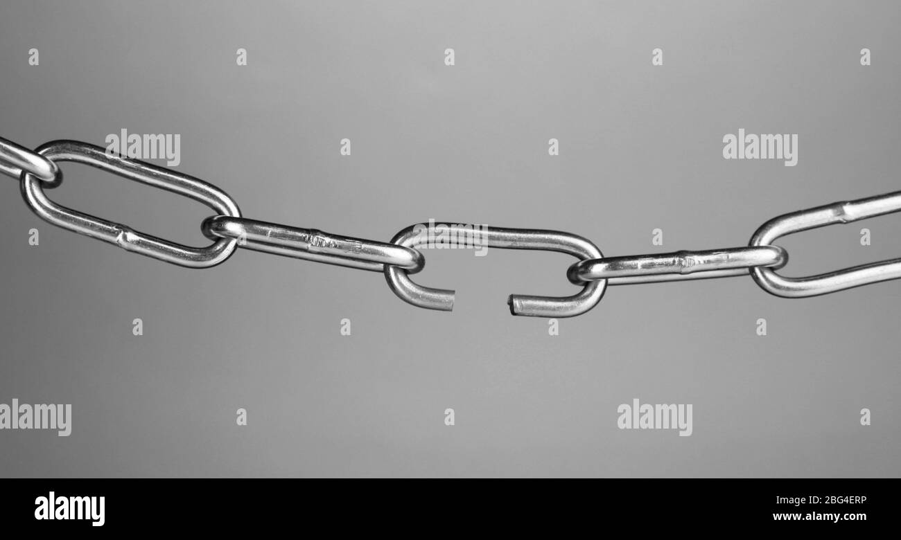 Kette auf grauem Hintergrund gebrochen Stockfoto