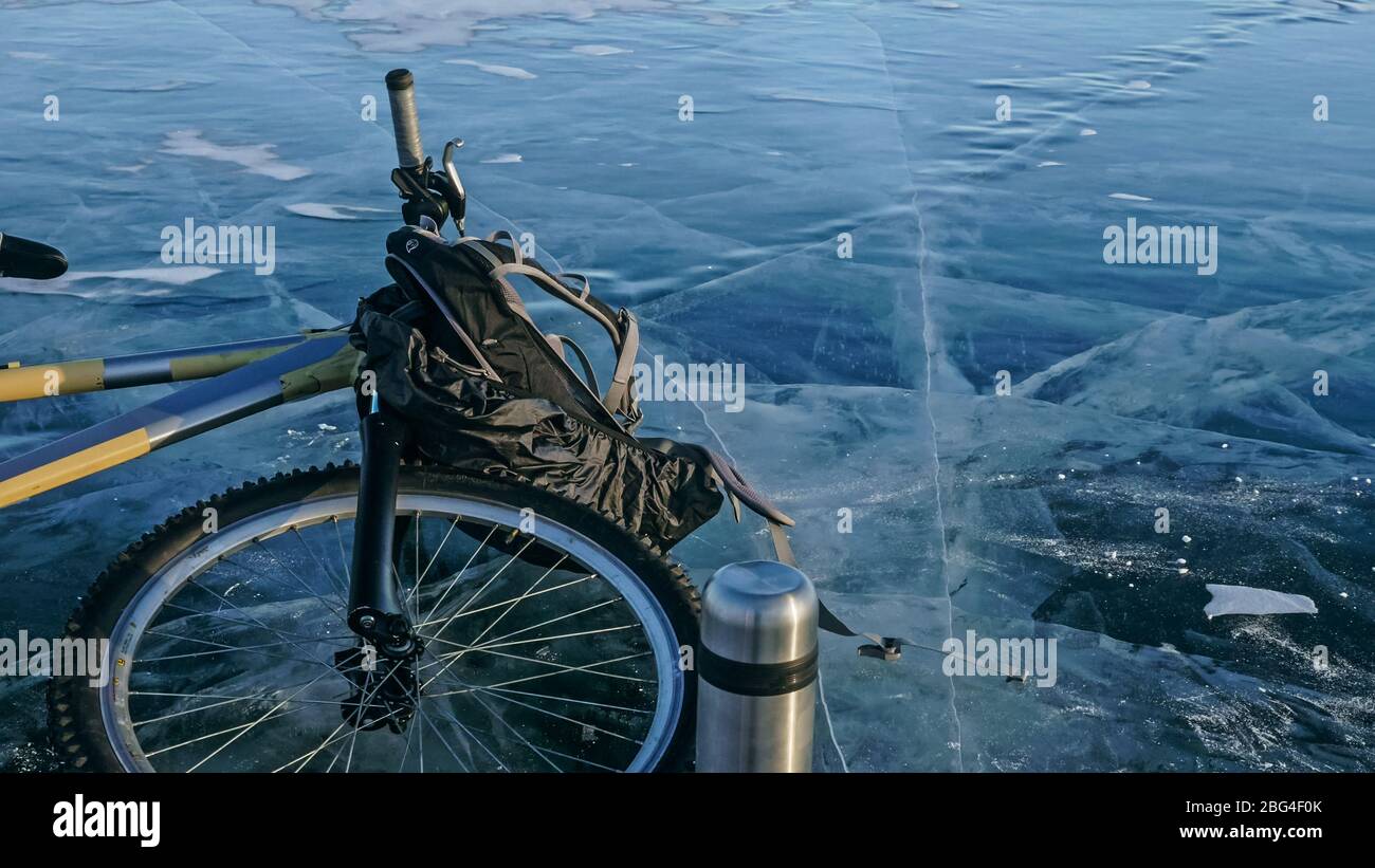 Mann und sein Fahrrad auf Eis. Er schaut auf das schöne Eis im Stockfoto