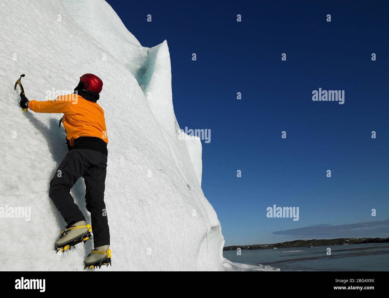 Mann, der im Süden Islands an einem Gletscher hochklettert Stockfoto