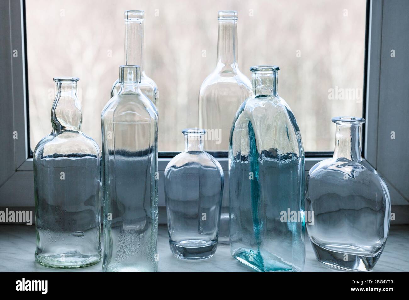 Viele leere betrunkene Flaschen auf der Fensterbank des Heims Fenster Stockfoto