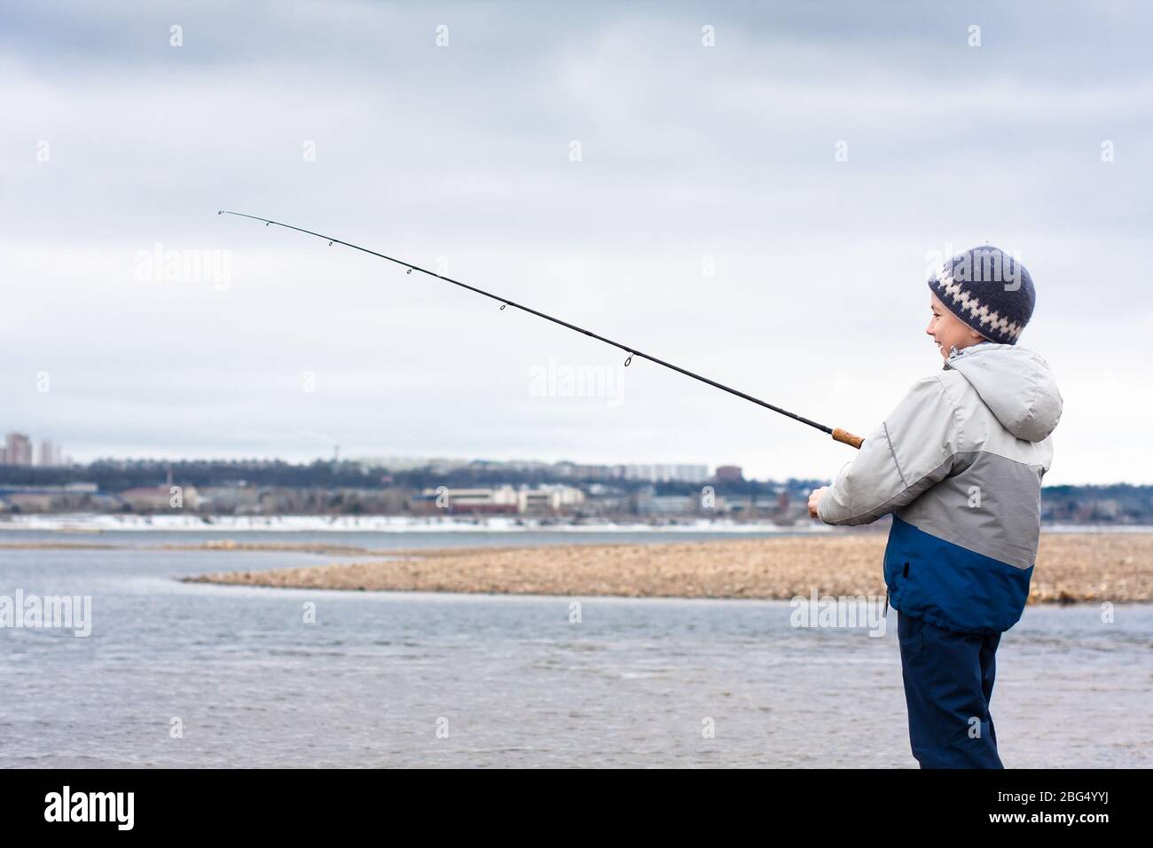 Junge mit einer Spinnrute auf dem Fluss Stockfoto