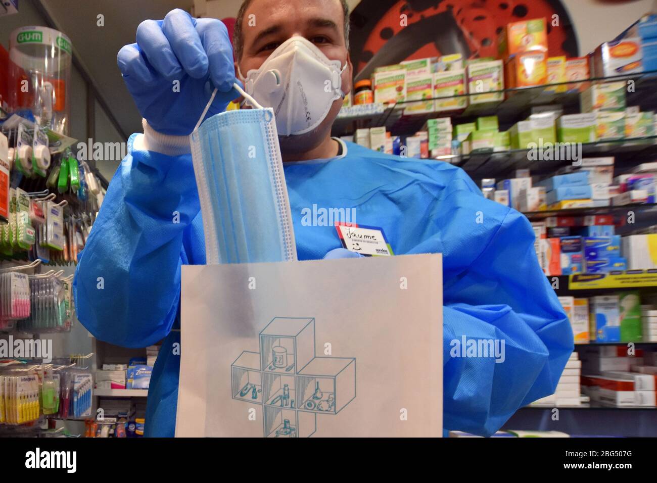 Ein Apotheker zeigt eine kostenlose OP-Maske, die die Regierung von Katalonien den Bürgern während der Coronavirus-Pandemie zur Verfügung gestellt hat.die Apotheken von Katalonien (Spanien) begannen heute, chirurgische Masken zu verteilen, um eine weitere Ansteckung aufgrund der Gesundheitskrise von Covid-19 zu verhindern, die die Regierung von Katalonien an die Bevölkerung schickt. Jeder Bürger erhält eine kostenlose Maske, die mit seinen Gesundheitskarten validiert wird, und wenn er eine zweite benötigt, muss der Bürger dafür bezahlen. Stockfoto