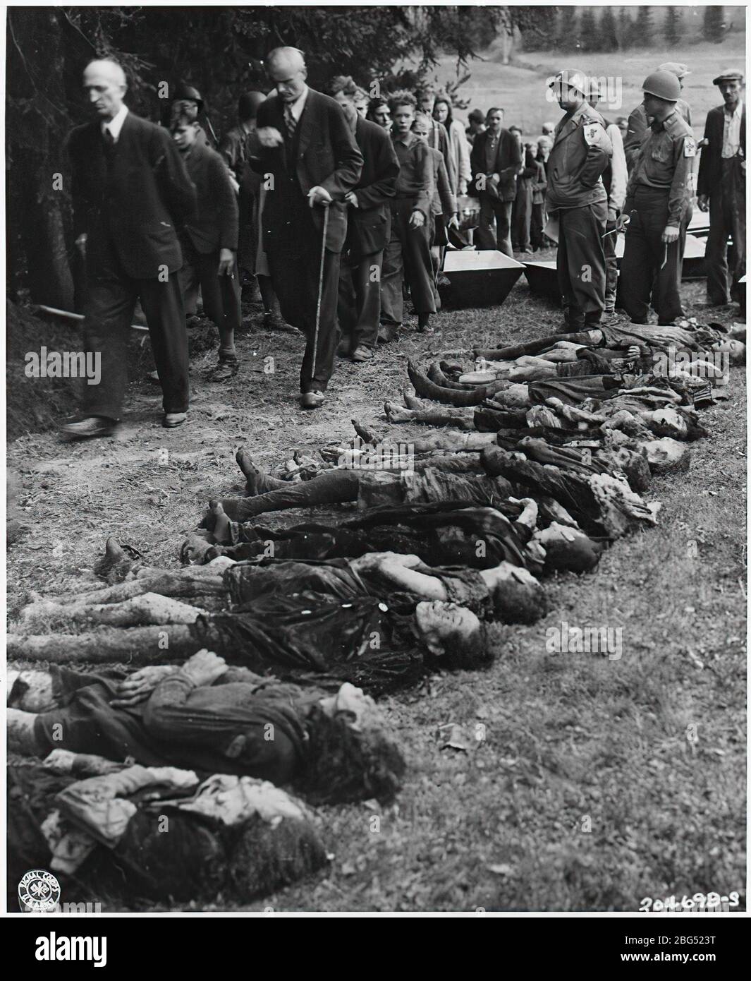 Dokumentation zum Zweiten Weltkrieg. Deutsche Zivilisten werden unter der Leitung von US-amerikanischen medizinischen Offizieren an einer Gruppe von 30 jüdischen Frauen vorbeigehen lassen, die von SS-Truppen verhungert wurden, um in der Tschechoslowakei 1945 Zeugen zu sein. Stockfoto