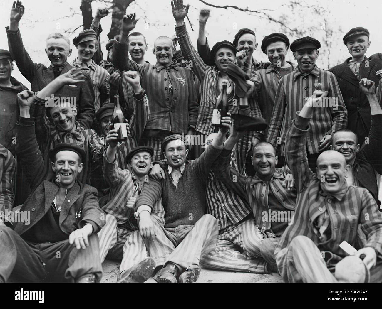 Dokumentation zum Zweiten Weltkrieg. Polnische Häftlinge des Konzentrationslagers Dachau stoßen auf ihre US-Befreier um April/Mai 1945 an Stockfoto