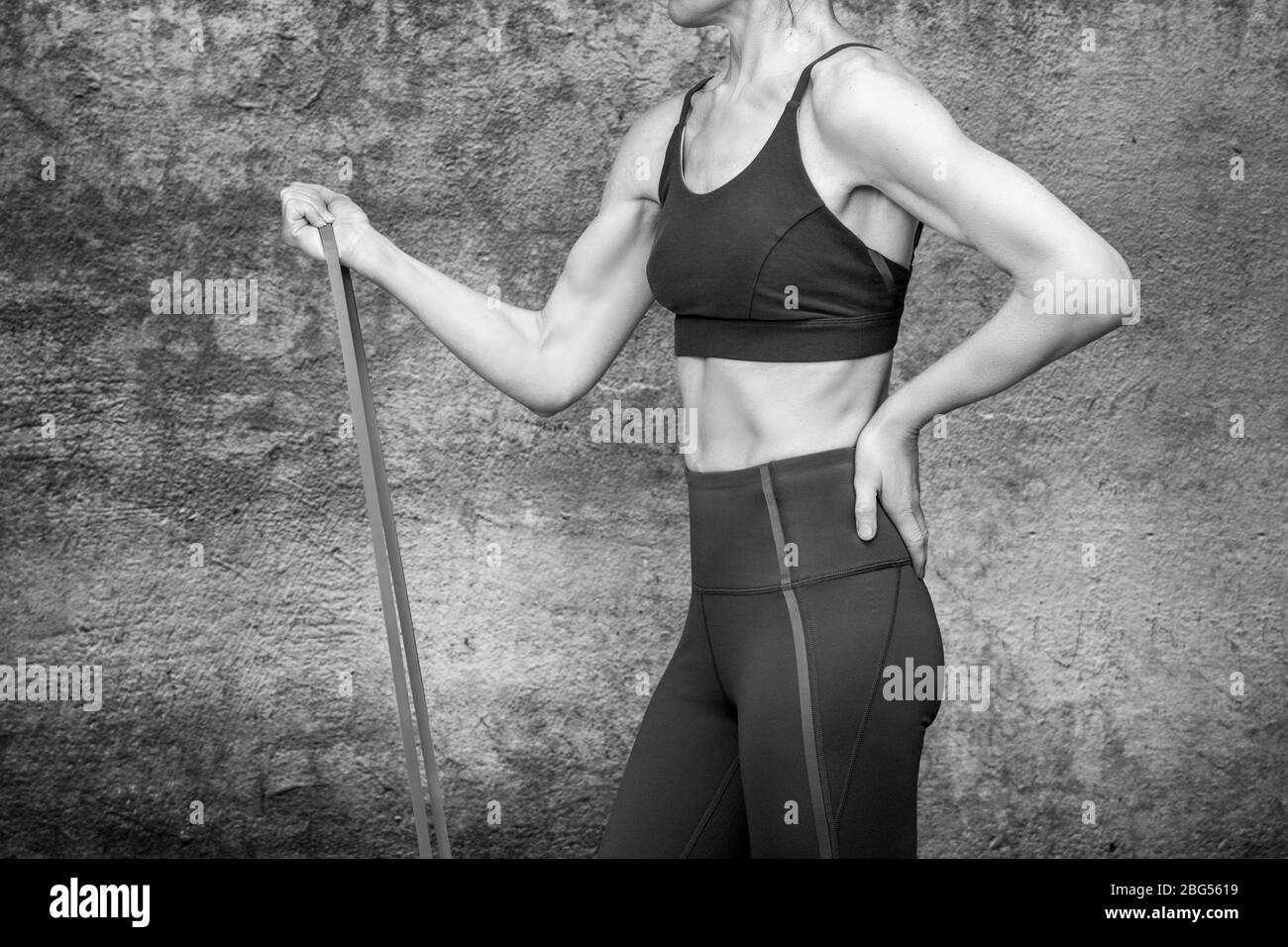 Nahaufnahme einer Frau mit einem Widerstandsband, um fit zu bleiben und Bewegung Stockfoto