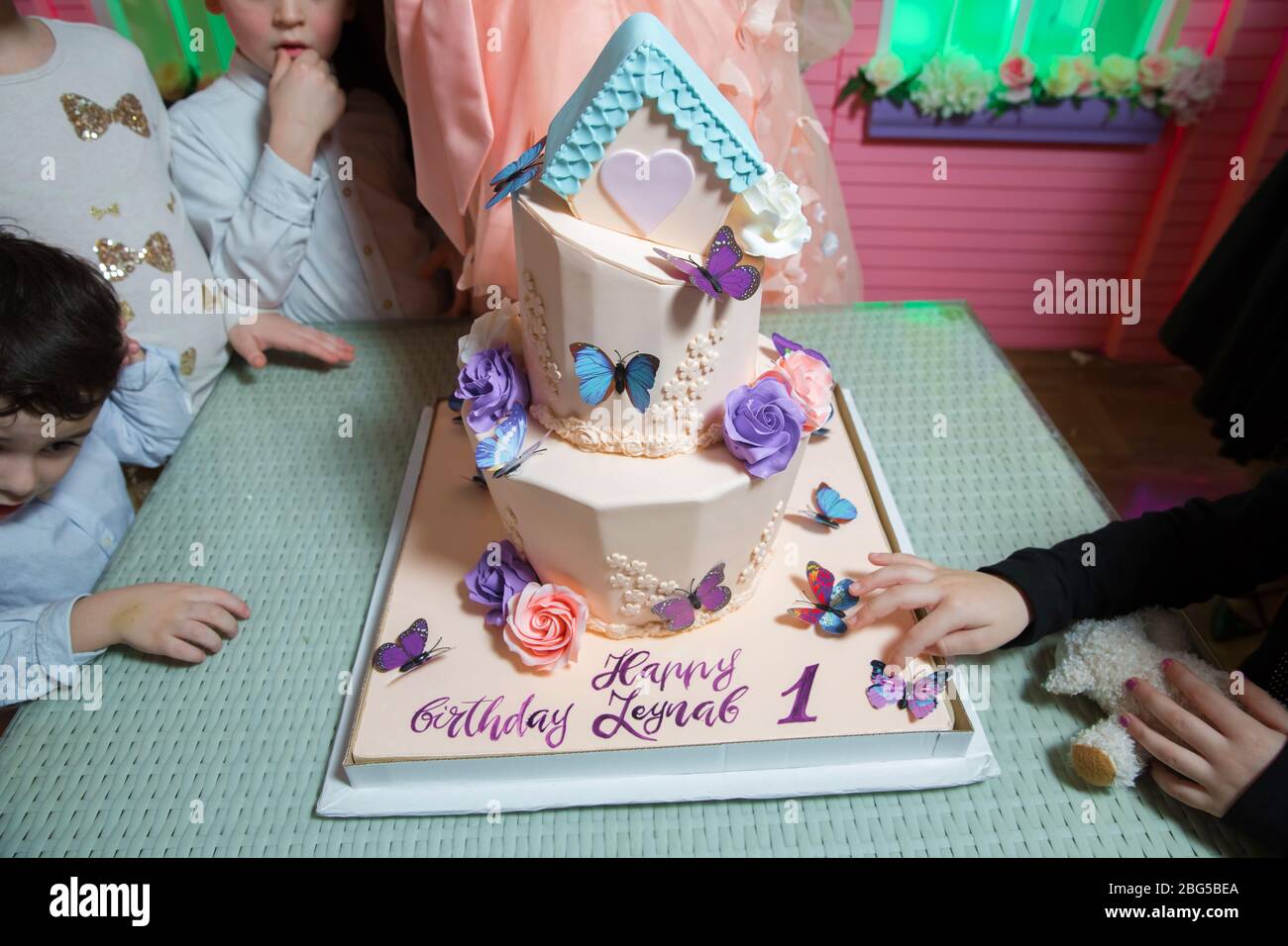 Nummer eins auf pinkfarbenem Hame Kuchen. Darüber gibt es Schmetterlinge und einen Kuchen. Baku, Aserbaidschan. 25.03.2019 . Stockfoto