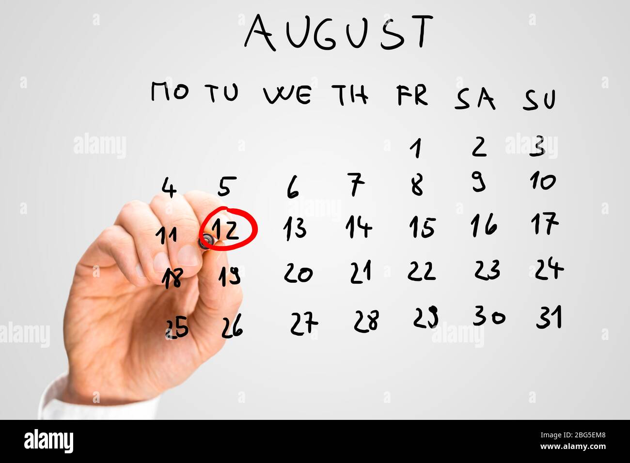 Männliche Hand markiert 12. August - Internationaler Jugendtag - auf virtuellen Kalender. Stockfoto