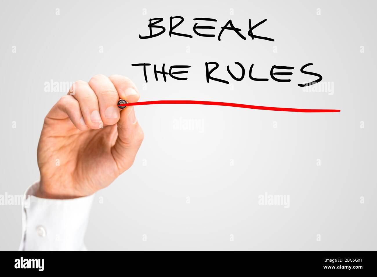 Konzeptionelle handschriftliche rote Unterstreichung auf Break the Rules Texte isoliert auf grauem Hintergrund. Stockfoto