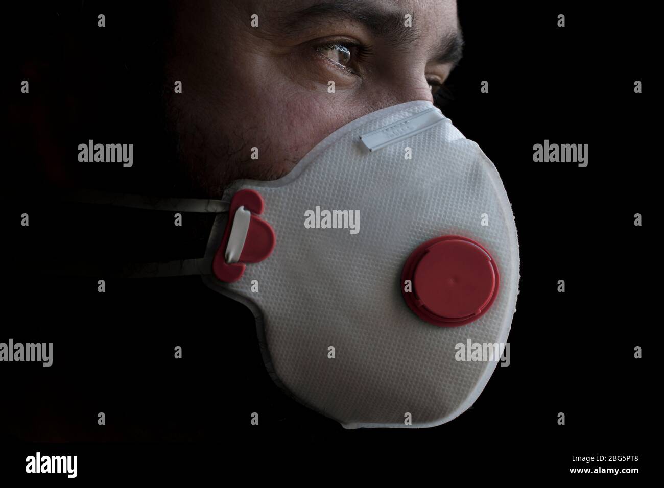Gesichtsmaske ffp3 (persönliche Schutzausrüstung PSA) für Pandemie, Krankheiten, Coronavirus COVID-19 und Verschmutzung. Ein besorgter Mann, der eine Einwegmaske trägt. Stockfoto