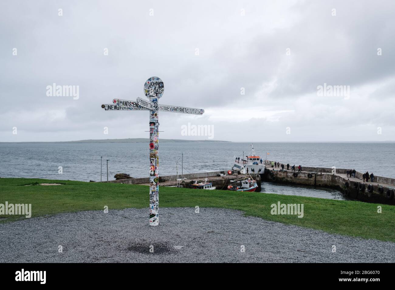 Berühmtes Wahrzeichen und Wegweiser am kleinen Hafen in John O' Groats, Caithness, Schottland, Großbritannien. Stockfoto