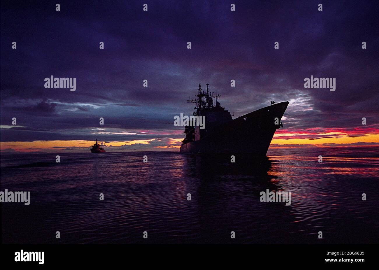 USS Anzio (CG 68), ein Kreuzer der Ticonderoga (Aegis) Klasse der US Navy, bei Sonnenuntergang während eines Rendezvous mit einer Osloer Klasse Fregatte der Norwegischen Marine in den Minches vor der Westküste Schottlands Stockfoto