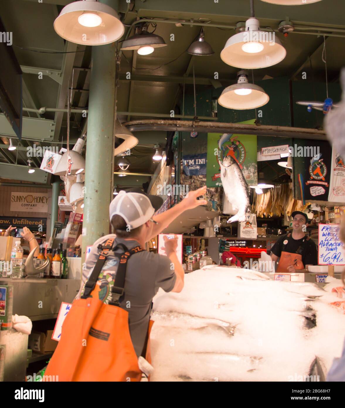 Mann wirft Fisch auf Pike Place Fish Market Stockfoto