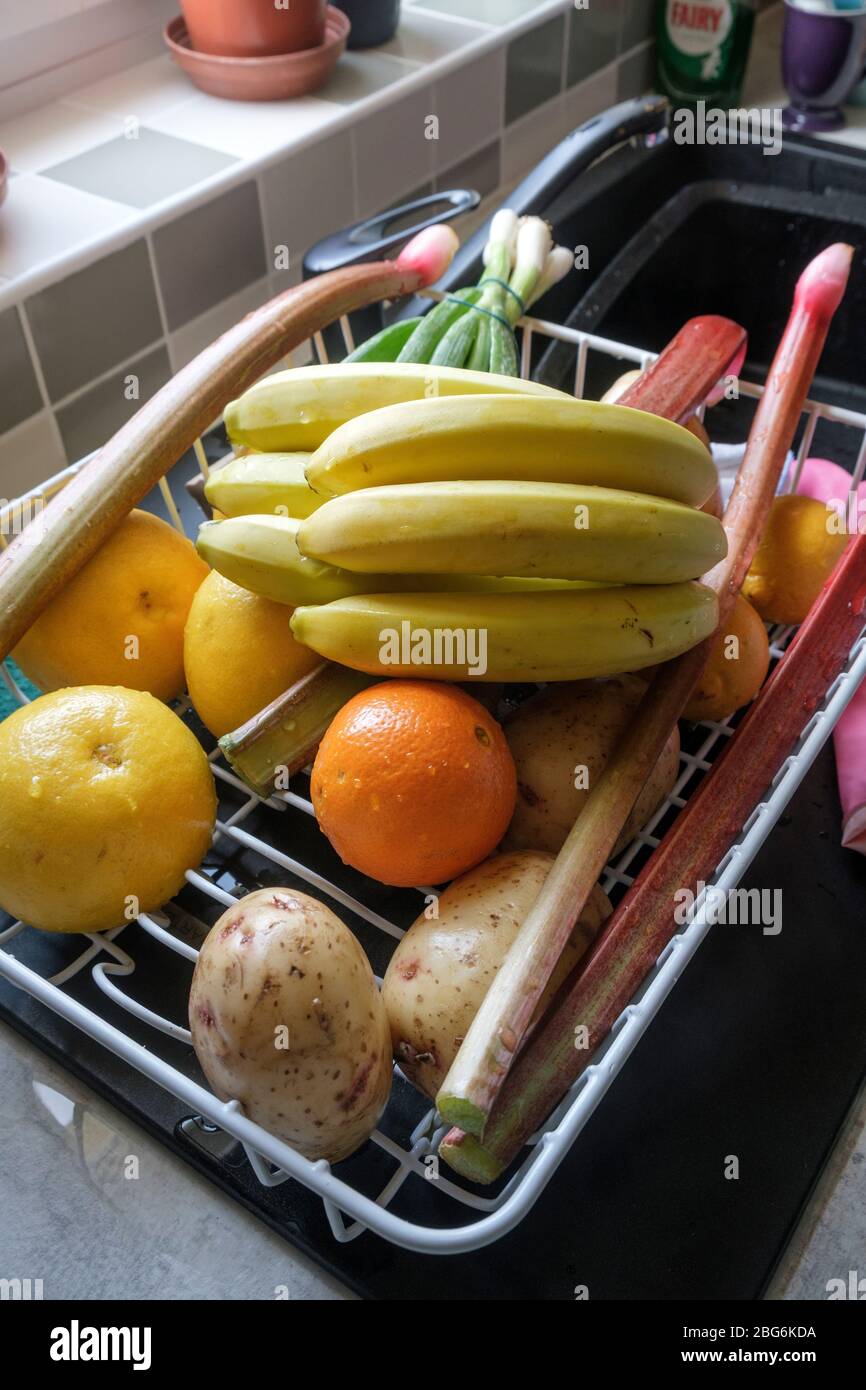 Waschen von frischem Obst und Gemüse, wenn Sie während der Pandemie vom Einkaufen zurückkehren Stockfoto