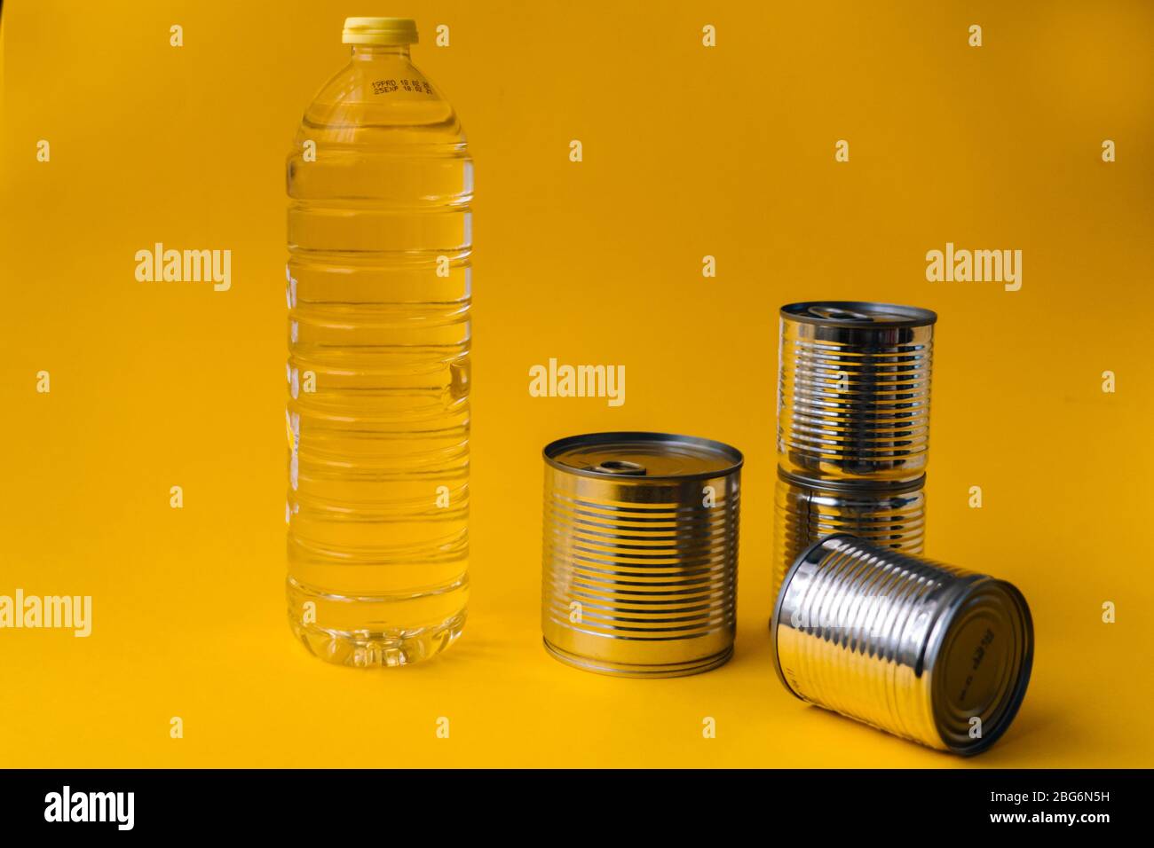 Lebensmittel-Lieferungen Krise Nahrungsmittelvorrat für Coronavirus Quarantäne Isolationsperiode in gelbem Hintergrund. Verschiedene Lebensmittel in Aluminiumdosen, Reis, Pasta. Essen d Stockfoto