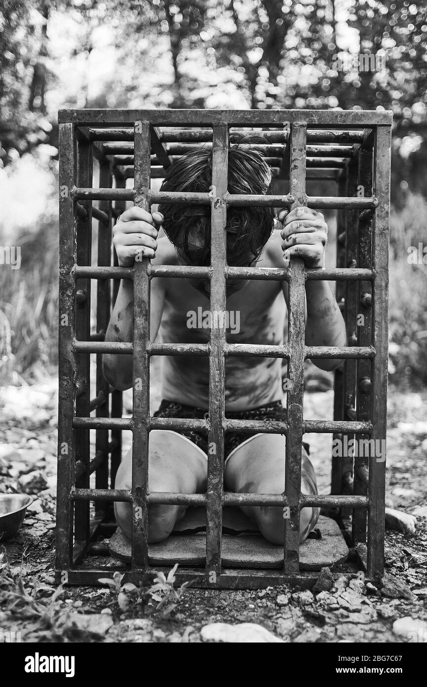 Der Junge ist im Gefängnis. Menschliches Kind gefangen genommen. Das Konzept der Entführung und des Menschenhandels. Stockfoto