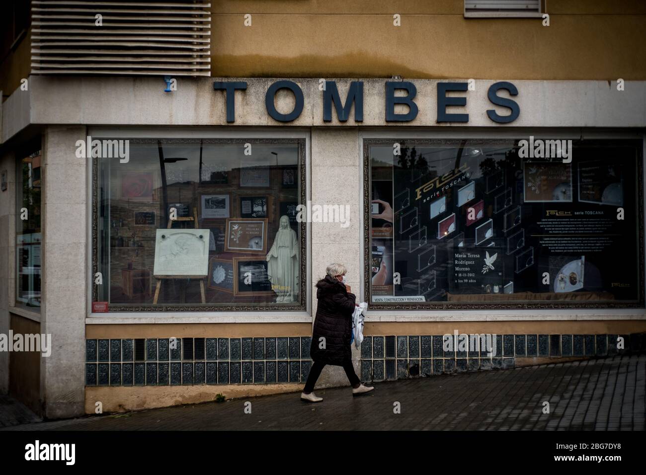 20. April 2020, Barcelona, Katalonien, Spanien - EINE Frau mit einer schützenden Gesichtsmaske geht an einem Gräberladen in Barcelona vorbei. Die Todesfälle durch das Coronavirus fallen in Spanien auf 399, während die bestätigten Fälle jetzt 200,000 übersteigen. Quelle: Jordi Boixareu/Alamy Live News Stockfoto