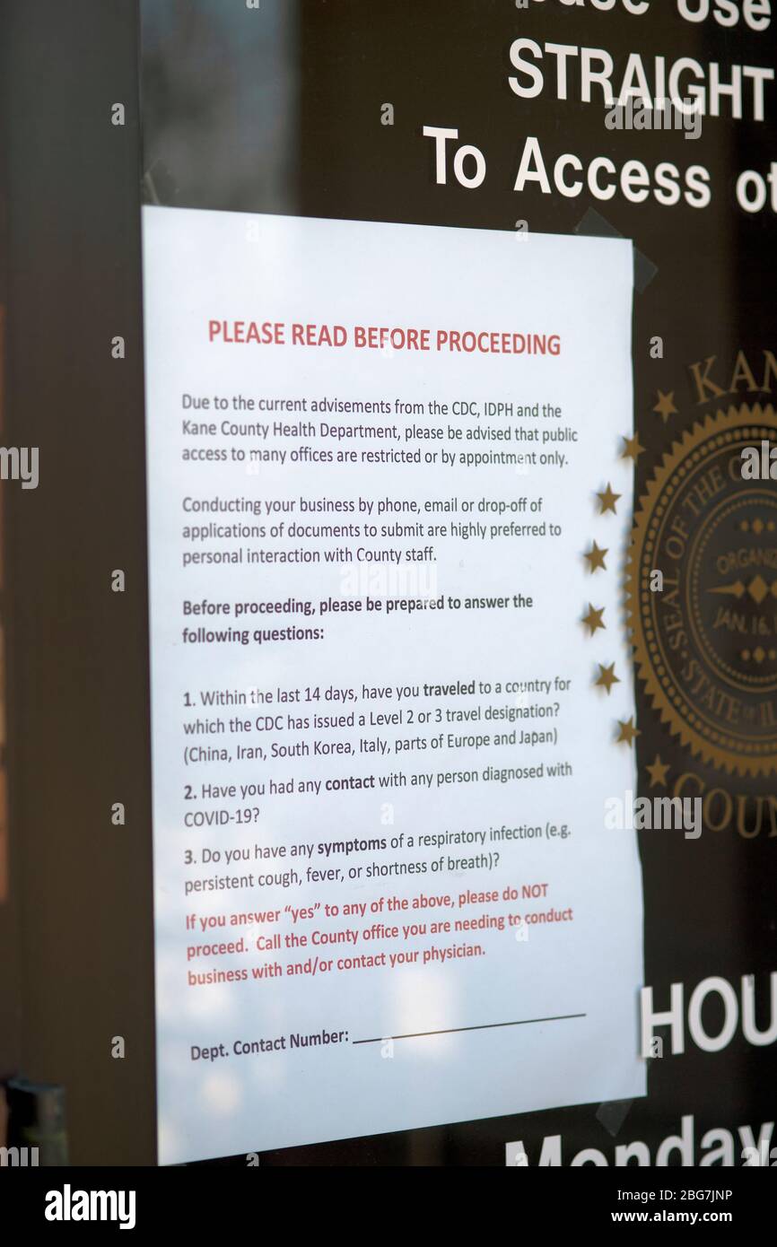 Genf, Illinois, USA. Schild an der Tür eines Kreisregierungszentrums listet den eingeschränkten Zugang zum Gebäude wegen der Coronavirus-Pandemie. Stockfoto