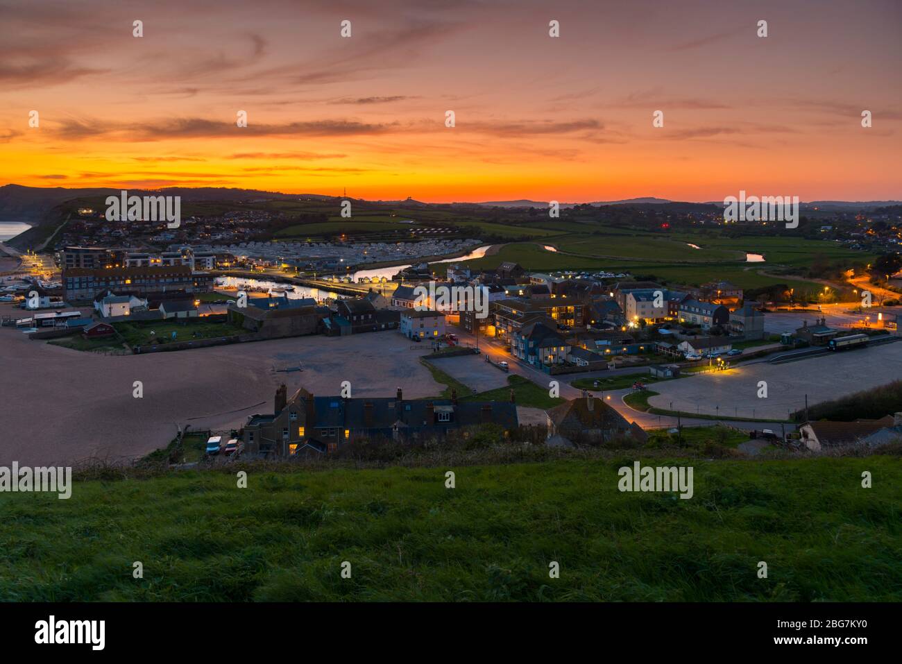 West Bay, Dorset, Großbritannien. April 2020. Wetter in Großbritannien. Der Himmel leuchtet orange kurz nach Sonnenuntergang im Badeort West Bay in Dorset mit dem ruhigen Wetter gesetzt, um diese Woche mit steigenden Temperaturen fortzusetzen. Bild: Graham Hunt/Alamy Live News Stockfoto