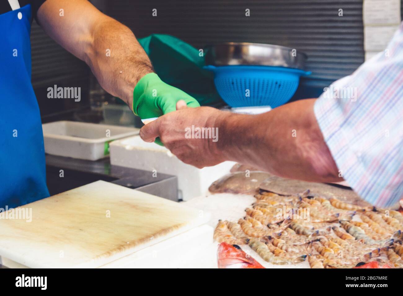 Menschen, die mit Bargeld in einem Markt bezahlen Stockfoto