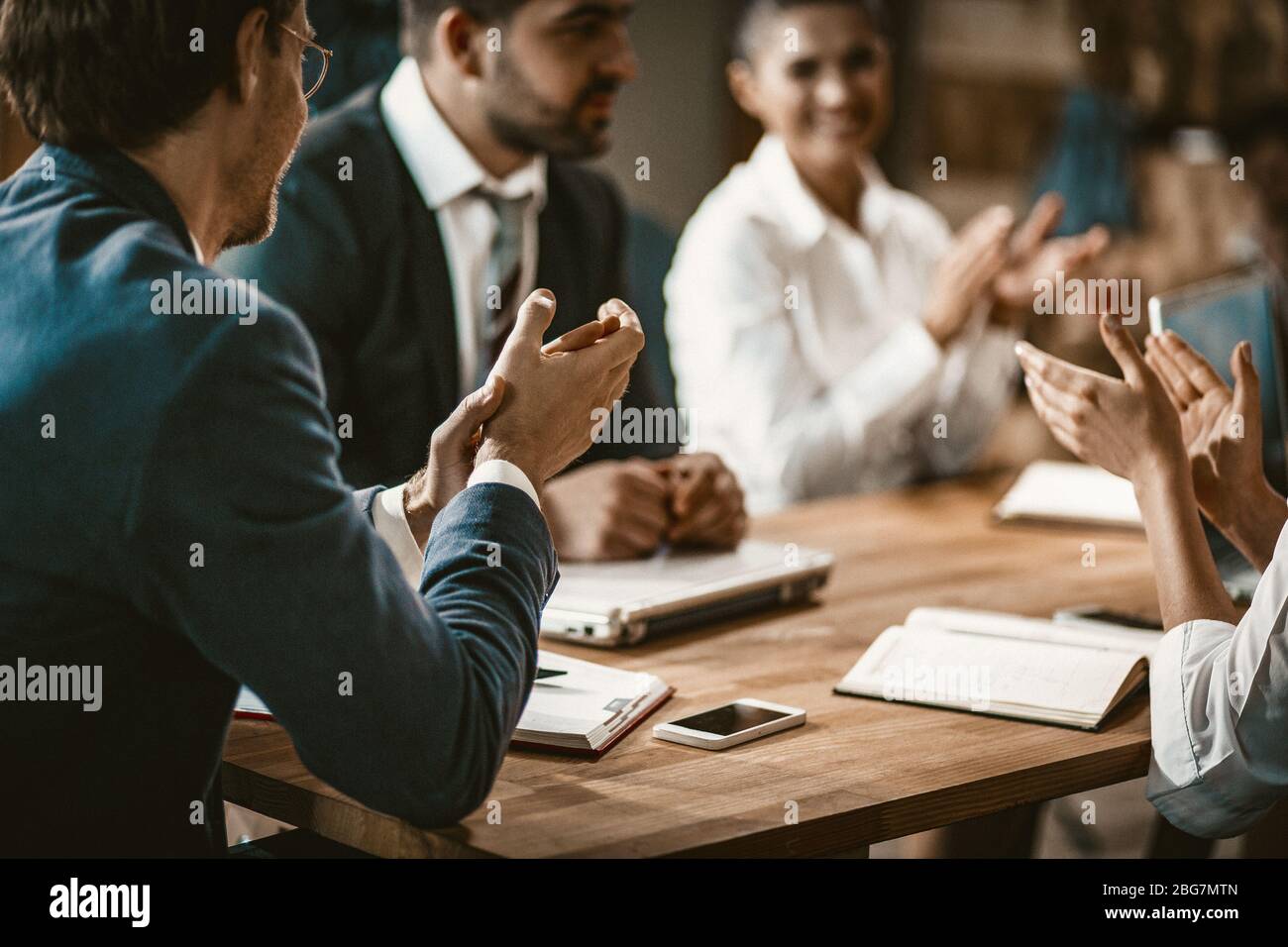Eine Gruppe von Geschäftsleuten applaudiert während eines Meetings Stockfoto